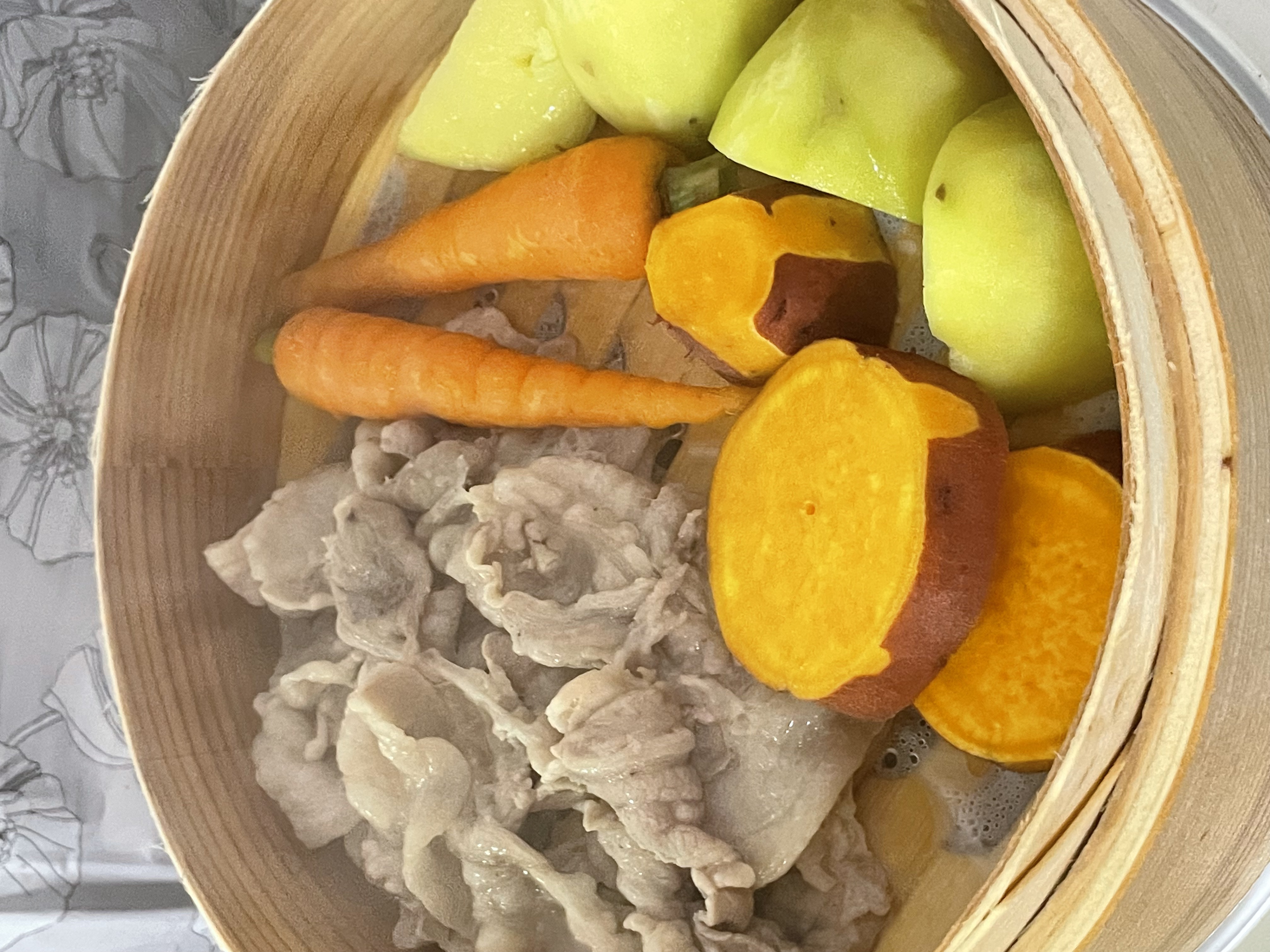 Steamed meat and vegetables in a bamboo basket